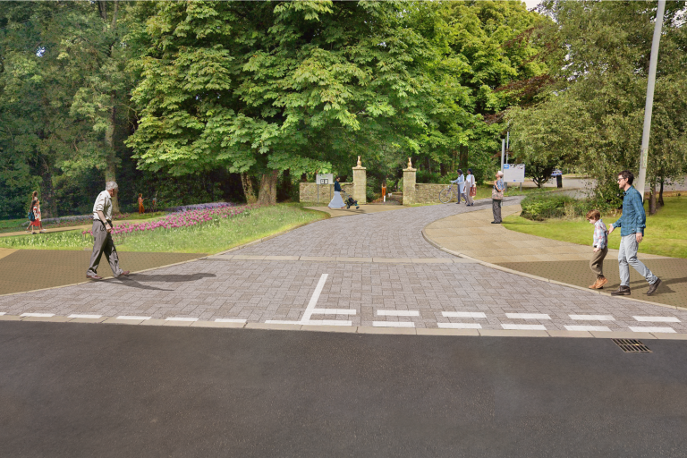 Artist impression of the entrance to Hall Park and the car park adjacent to Workington Skate Park. The pillars at the entrance to the park are visible through mature trees and there is a cobbled area on the road denoting the enhanced vehicle entrance.