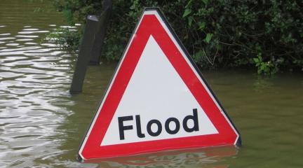 image shows a sign that says flood standing in water