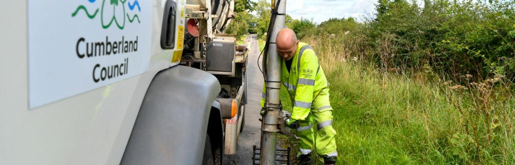 Highways staff member cleaning drains